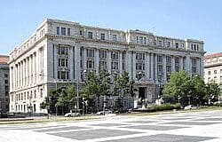 A large white building with trees in front of it.