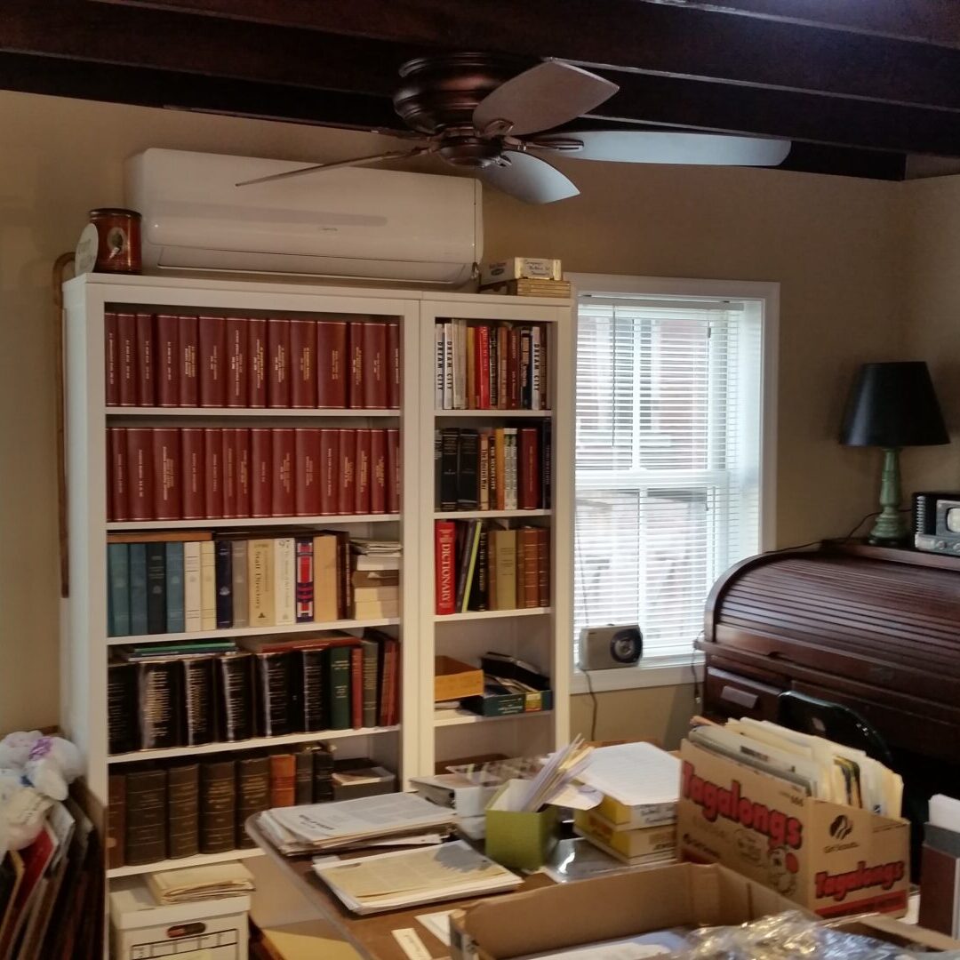 A room with many books and boxes on the floor